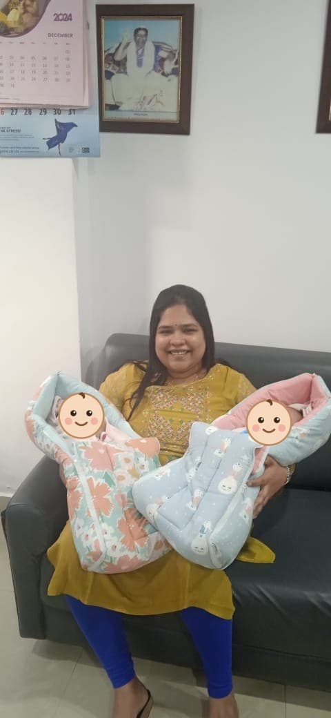 A mother holding her newborn twins