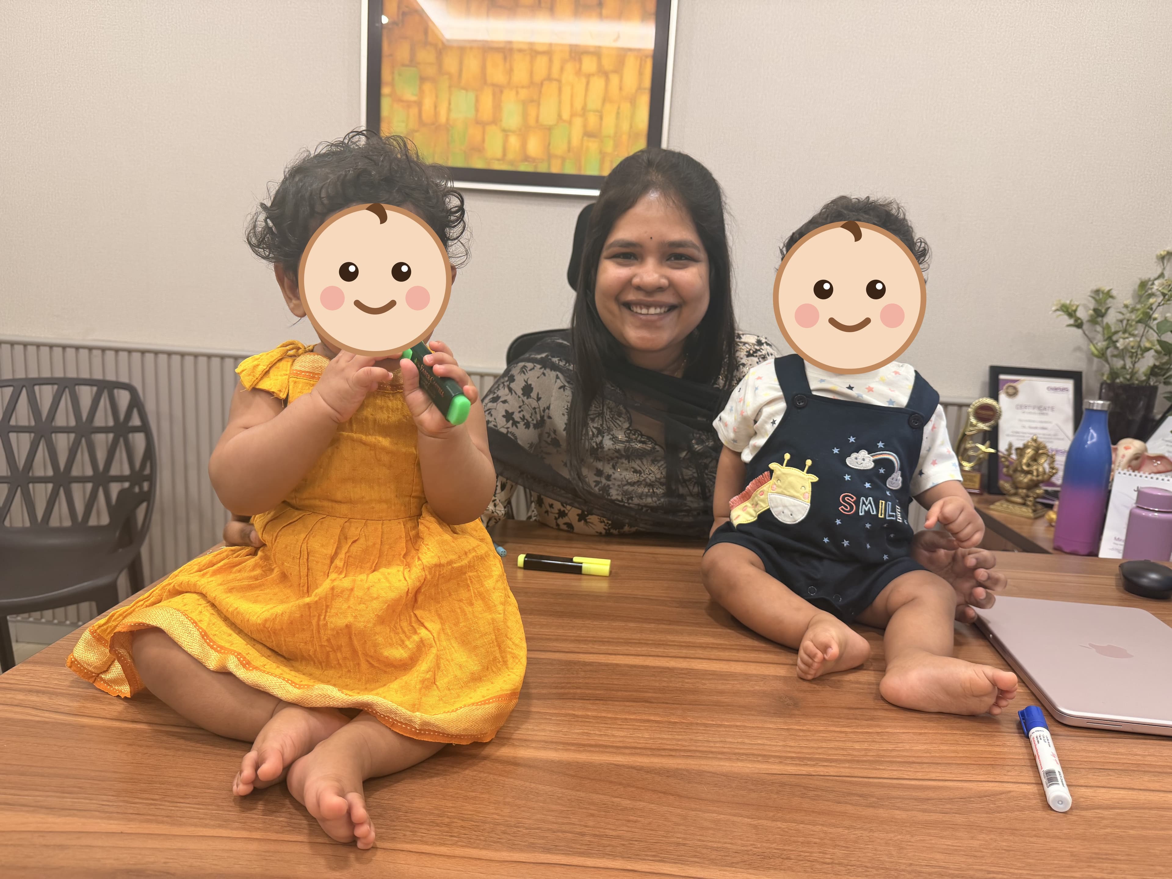 Twin toddlers sitting with their mother at the clinic